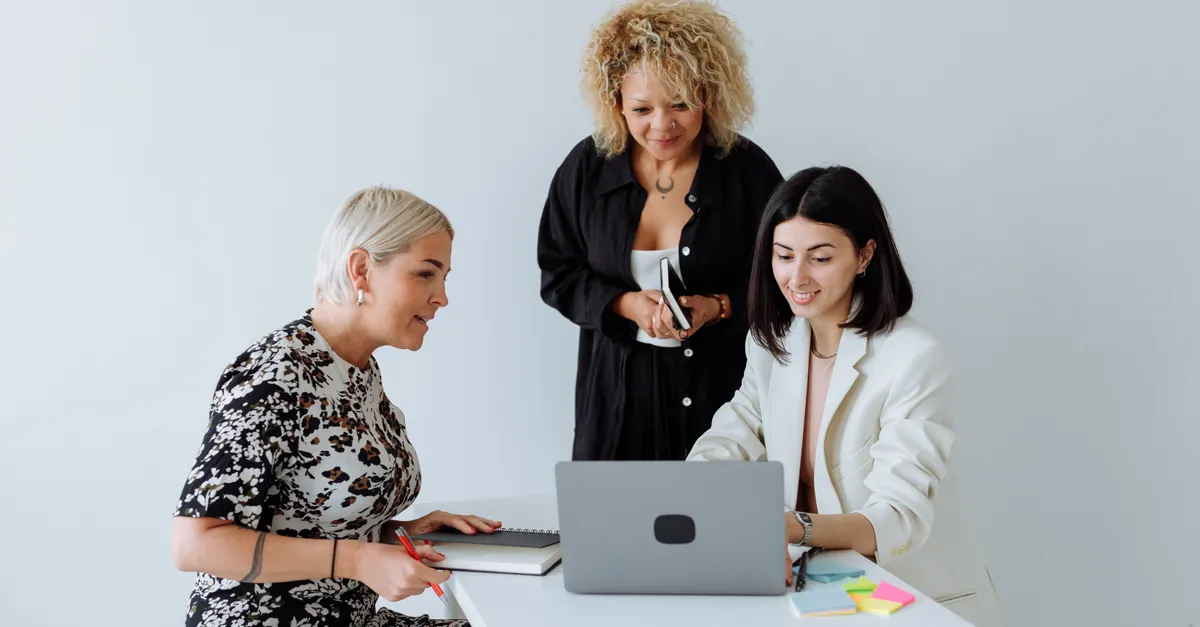 Mulheres empreendedoras reunidas em torno de um notebook durante uma sessão de planejamento
